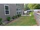 This backyard has a patio with a dining set, lush grass, and beautiful landscaping at 4990 Arbor View Nw Pkwy, Acworth, GA 30101
