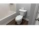 Bathroom featuring a toilet, white baseboards, and tiled bathtub at 4990 Arbor View Nw Pkwy, Acworth, GA 30101