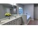 Bathroom featuring a double vanity, large mirror, separate tub, and neutral tile flooring at 4990 Arbor View Nw Pkwy, Acworth, GA 30101