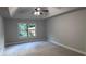 Spacious bedroom with plush carpet, ceiling fan, and a bright window overlooking the backyard at 4990 Arbor View Nw Pkwy, Acworth, GA 30101