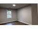 A simple bedroom featuring modern hardwood flooring and a large window at 4990 Arbor View Nw Pkwy, Acworth, GA 30101