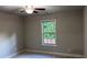 This bedroom features neutral walls, carpet flooring, a ceiling fan, and a bright window at 4990 Arbor View Nw Pkwy, Acworth, GA 30101