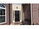 Close-up of the front door featuring brick accents and a decorative light fixture at 4990 Arbor View Nw Pkwy, Acworth, GA 30101
