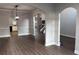 Open-concept living room with hardwood flooring, archways and views into the kitchen and staircase at 4990 Arbor View Nw Pkwy, Acworth, GA 30101