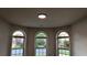 Bright living room showcasing three large arched windows with outdoor views and recessed lighting at 4990 Arbor View Nw Pkwy, Acworth, GA 30101