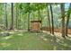 Secluded backyard featuring mature trees, a rustic shed, a fire pit, and a wooden fence at 1341 Little Deer Run, Canton, GA 30114