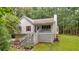 View of the exterior with an inviting front porch, American flag, and mature trees at 1341 Little Deer Run, Canton, GA 30114