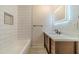 Well lit bathroom with white tiled tub, modern vanity and countertop, and LED mirror at 1348 Branchwood Dr, Snellville, GA 30078