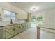 Renovated kitchen featuring green cabinets, granite counters, a new backsplash, and sliding doors to the backyard at 1348 Branchwood Dr, Snellville, GA 30078