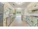 Updated kitchen with stainless steel appliances, granite counters, green cabinets, white backsplash, and backyard access at 1348 Branchwood Dr, Snellville, GA 30078