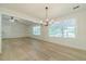 Bright living room featuring wood-look floors, modern chandelier, neutral paint, and large windows for ample natural light at 1348 Branchwood Dr, Snellville, GA 30078