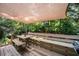 Wooden deck shaded by an awning, surrounded by lush greenery and a view of the backyard at 2208 Mountain Springs Nw Ct, Kennesaw, GA 30144