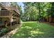 Large backyard featuring a deck, lush greenery, a stone path and a wooden fence at 2208 Mountain Springs Nw Ct, Kennesaw, GA 30144