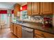 Bright kitchen features wooden cabinetry, granite countertops, tile backsplash, and stainless steel dishwasher at 2208 Mountain Springs Nw Ct, Kennesaw, GA 30144