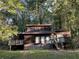 Wood cabin-style home with a deck, surrounded by lush trees at 2917 Katherine Valley Rd, Decatur, GA 30032