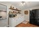 Finished bar area featuring shelves of liquor, a black fridge, a microwave, and a prep sink at 9125 Patrick Pl, Winston, GA 30187