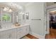 Bright bathroom featuring double vanity, walk-in closet, and hardwood floors at 9125 Patrick Pl, Winston, GA 30187