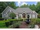 Beautiful gray house with fountain, surrounded by lush, manicured landscaping and mature trees at 9125 Patrick Pl, Winston, GA 30187