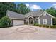 Elegant gray home with a circular driveway and manicured landscaping in a serene, wooded setting at 9125 Patrick Pl, Winston, GA 30187