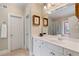 Well-lit bathroom with a single vanity, white cabinets, and a framed mirror above the sink at 2429 Kirk Nw Ln, Kennesaw, GA 30152