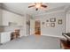 This bonus room with built-ins has grey paint, a ceiling fan, and stairs leading down to the lower level at 2429 Kirk Nw Ln, Kennesaw, GA 30152