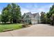 Beautifully landscaped front yard of a two-story home with a spacious driveway and three-car garage at 2429 Kirk Nw Ln, Kennesaw, GA 30152