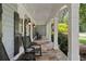 Covered front porch featuring stone flooring, rocking chairs, and white columns at 2429 Kirk Nw Ln, Kennesaw, GA 30152
