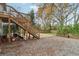 Backyard featuring a wooden deck with stairs and a gravel area with mature trees at 761 Bellemeade Nw Ave, Atlanta, GA 30318