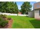 Large, grassy backyard, landscaped with mature trees and garden beds at 2559 Dunhaven Gln, Snellville, GA 30078