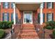 Home's front entrance featuring brick steps, black wrought iron railings, a covered entryway, and brick columns at 2559 Dunhaven Gln, Snellville, GA 30078