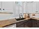 Close up of a kitchen sink with white cabinets, granite counter tops and stainless steel appliances at 2559 Dunhaven Gln, Snellville, GA 30078
