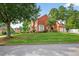 Brick home's side view, showing a large yard, professional landscaping, and a two car side-entry garage at 2559 Dunhaven Gln, Snellville, GA 30078