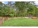 Grassy backyard featuring a wooden fence and mature trees at 2670 Trotters Pointe Drive Dr, Snellville, GA 30039