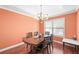 Inviting dining room features a chandelier, wood floors, and natural light from a window at 2670 Trotters Pointe Drive Dr, Snellville, GA 30039