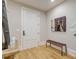 Hallway features hardwood floors, a white door, artwork, and a bench at 328 Stonemont Dr, Atlanta, GA 30305