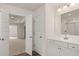 Bathroom with double doors that lead to the bedroom and a sink with white cabinets at 13568 Whitman Lane, Covington, GA 30014