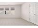 Bright bedroom with neutral carpet, three windows, and a closet with double doors at 13568 Whitman Lane, Covington, GA 30014