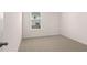 Clean bedroom featuring light colored carpet, white walls, and natural light at 13568 Whitman Lane, Covington, GA 30014