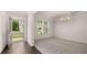 A bright, open room adjacent to the entry with an elegant chandelier, windows, and neutral carpet at 13568 Whitman Lane, Covington, GA 30014