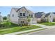 Two-story home features a grey and white brick exterior, lush green lawn, and convenient two-car garage at 13568 Whitman Lane, Covington, GA 30014