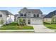 Charming two-story home with grey and white brick exterior, a well-manicured lawn, and a two car garage at 13568 Whitman Lane, Covington, GA 30014