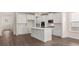 Open kitchen design with an island, white cabinets and stainless steel appliances at 13568 Whitman Lane, Covington, GA 30014