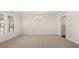 Bright, open-concept living room features large windows and a modern chandelier at 13568 Whitman Lane, Covington, GA 30014