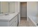 Bathroom featuring double sinks, a soaking tub, and access to a walk-in closet at 500 Charleston Pl, Villa Rica, GA 30180