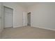 A carpeted bedroom features a closet and open doorways with a view to other rooms at 500 Charleston Pl, Villa Rica, GA 30180