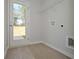 Well-lit laundry room with light-colored wood floors and a door to the outside at 500 Charleston Pl, Villa Rica, GA 30180