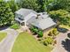 Aerial view of a beautiful home featuring stone accents, lush landscaping, and a circular driveway at 2166 Tanglewood Dr, Snellville, GA 30078