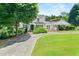 Beautiful two-story home featuring a well-maintained lawn, mature trees, and a circular driveway at 2166 Tanglewood Dr, Snellville, GA 30078