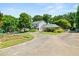 Gorgeous home with lush landscaping, mature trees, and a circular driveway leading up to the house at 2166 Tanglewood Dr, Snellville, GA 30078