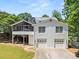 Two-story house features a stone chimney, covered porch, garage, and well-maintained backyard at 2166 Tanglewood Dr, Snellville, GA 30078